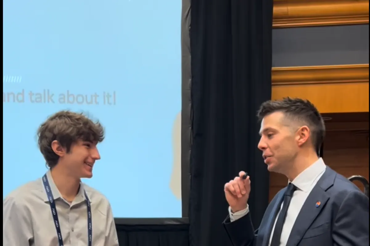 A UWSP AMA member talking with a speaker after a conference session.