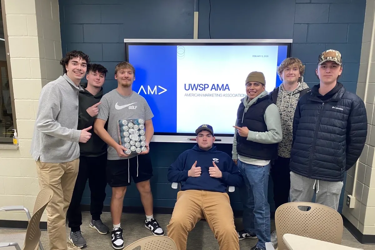 UWSP AMA members grouped in front of the chapter logo at a chapter night.