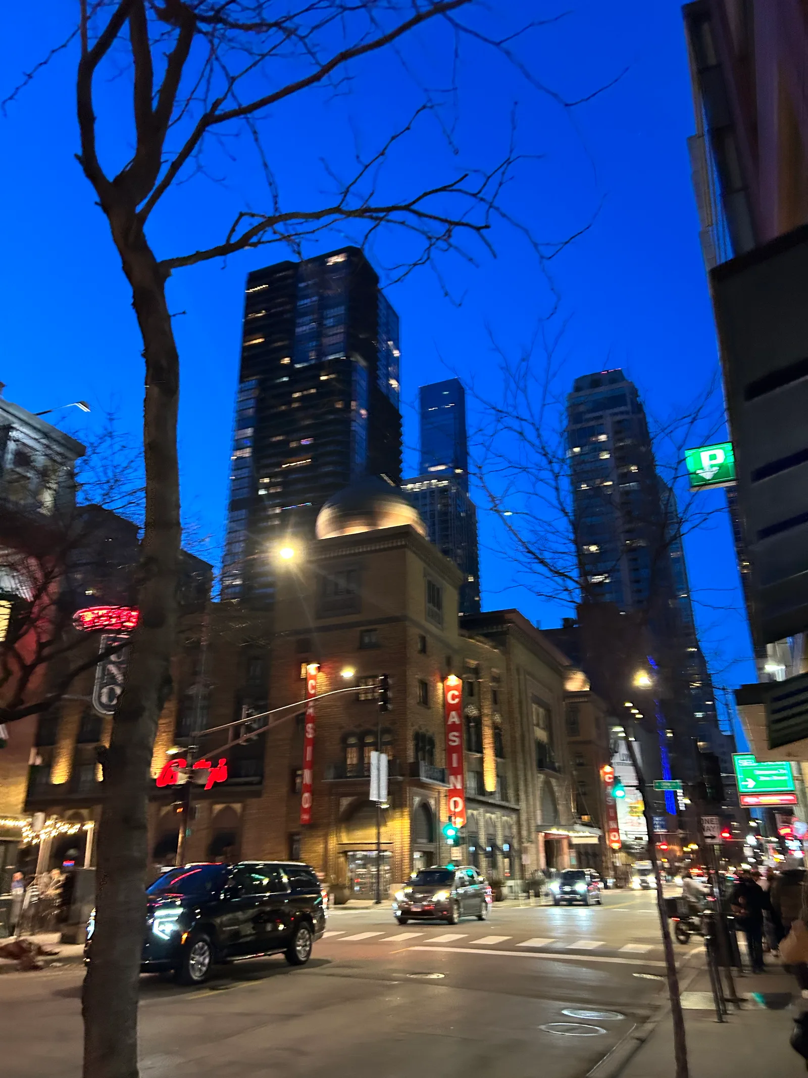 Traffic and buildings along a Chicago street after sunset.